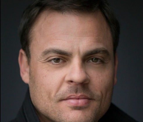 Brad McMurray posing for his photoshoot by wearing black jacket.